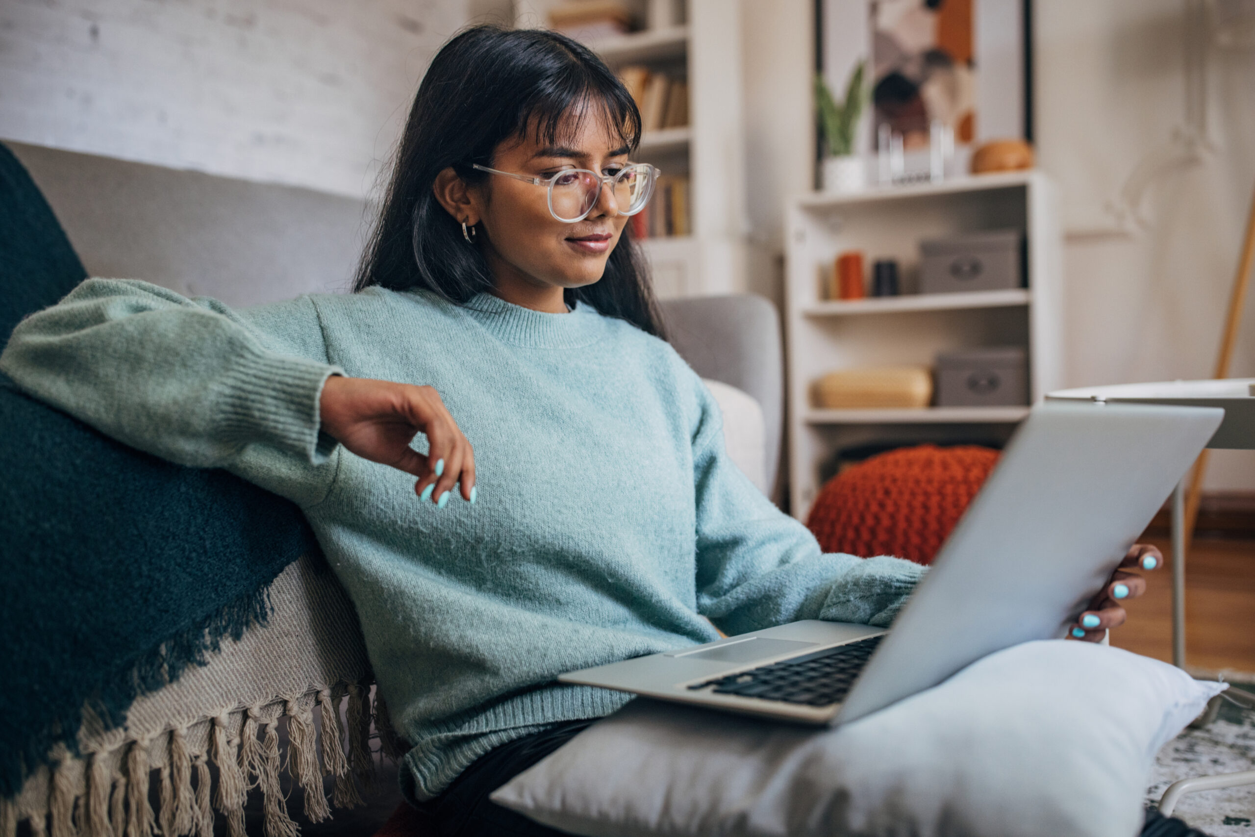 Woman relaxing with laptop in modern home